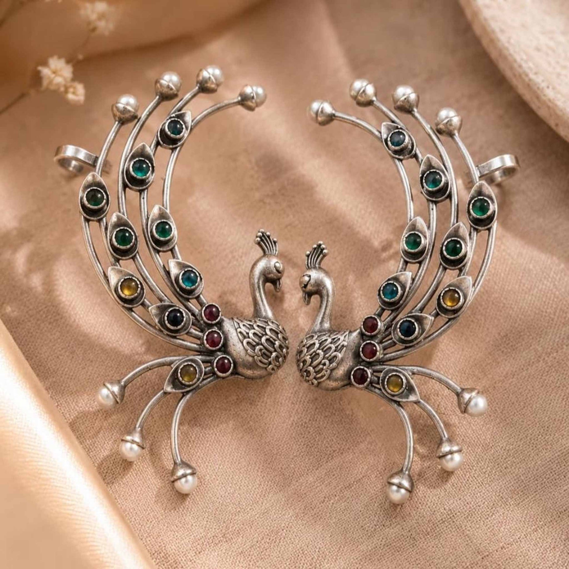 Peacock stone ear cuff earrings on beige fabric