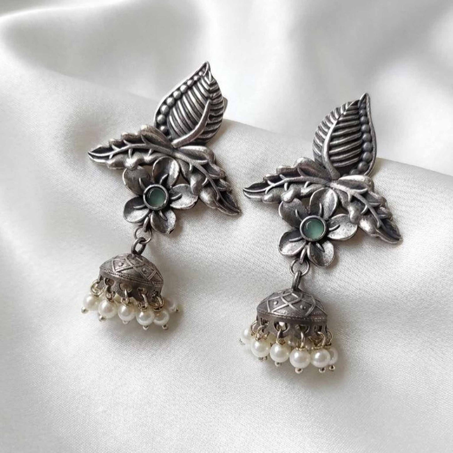 Elegant satin flatlay of floral pearl ethnic earrings