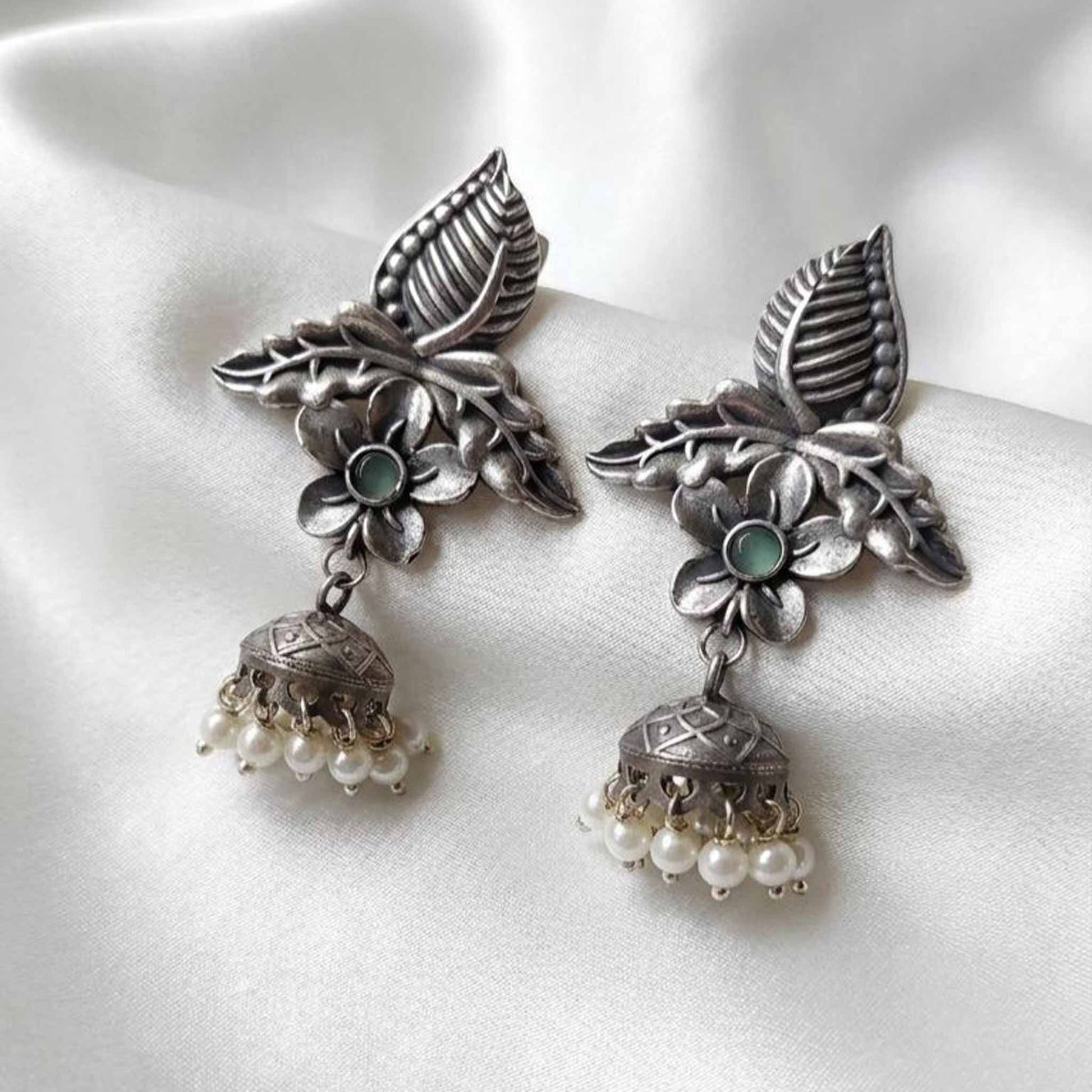 Elegant satin flatlay of floral pearl ethnic earrings