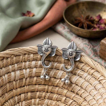 Traditional Ganesha earrings displayed on woven basket