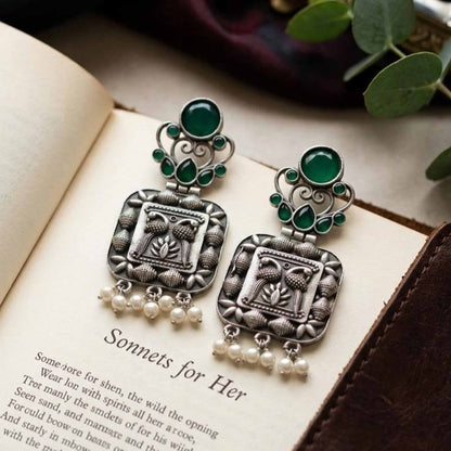 Emerald pearl drop German silver earrings flatlay styling